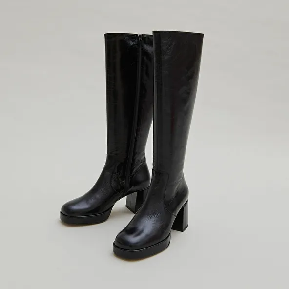 Heeled platform boots in black distressed leather